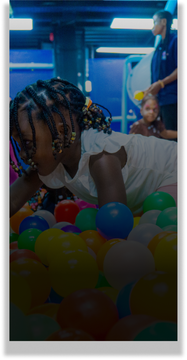 Child playing in a colorful ball pit